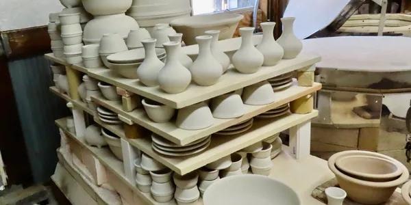 Bisque-fired pottery pieces on kiln shelves